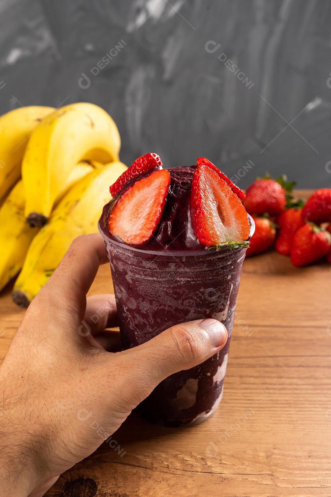 Homem segurando um Smoothie de Sorvete Brasileiro de Açaí Berry Congelado Imagem JPG