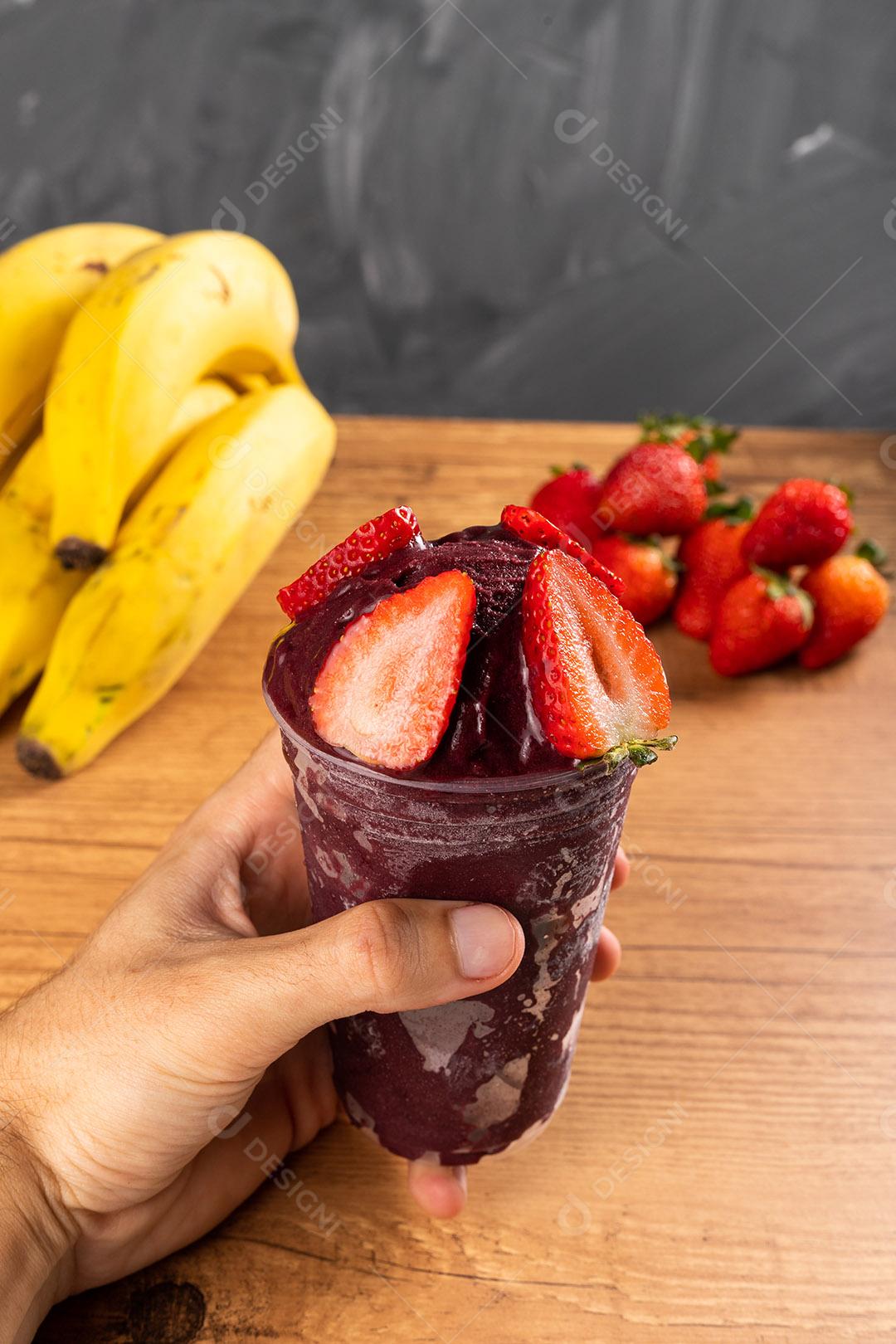 Homem segurando um Smoothie de Sorvete Brasileiro de Açaí Berry Congelado Imagem JPG