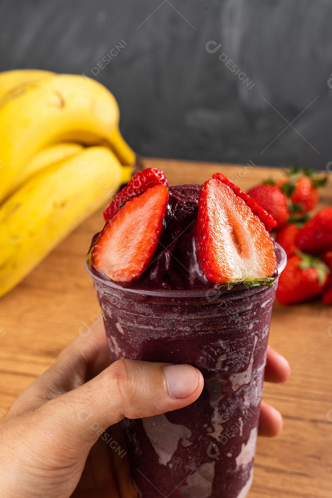 Homem segurando um Smoothie de Sorvete Brasileiro de Açaí Berry Congelado Imagem JPG