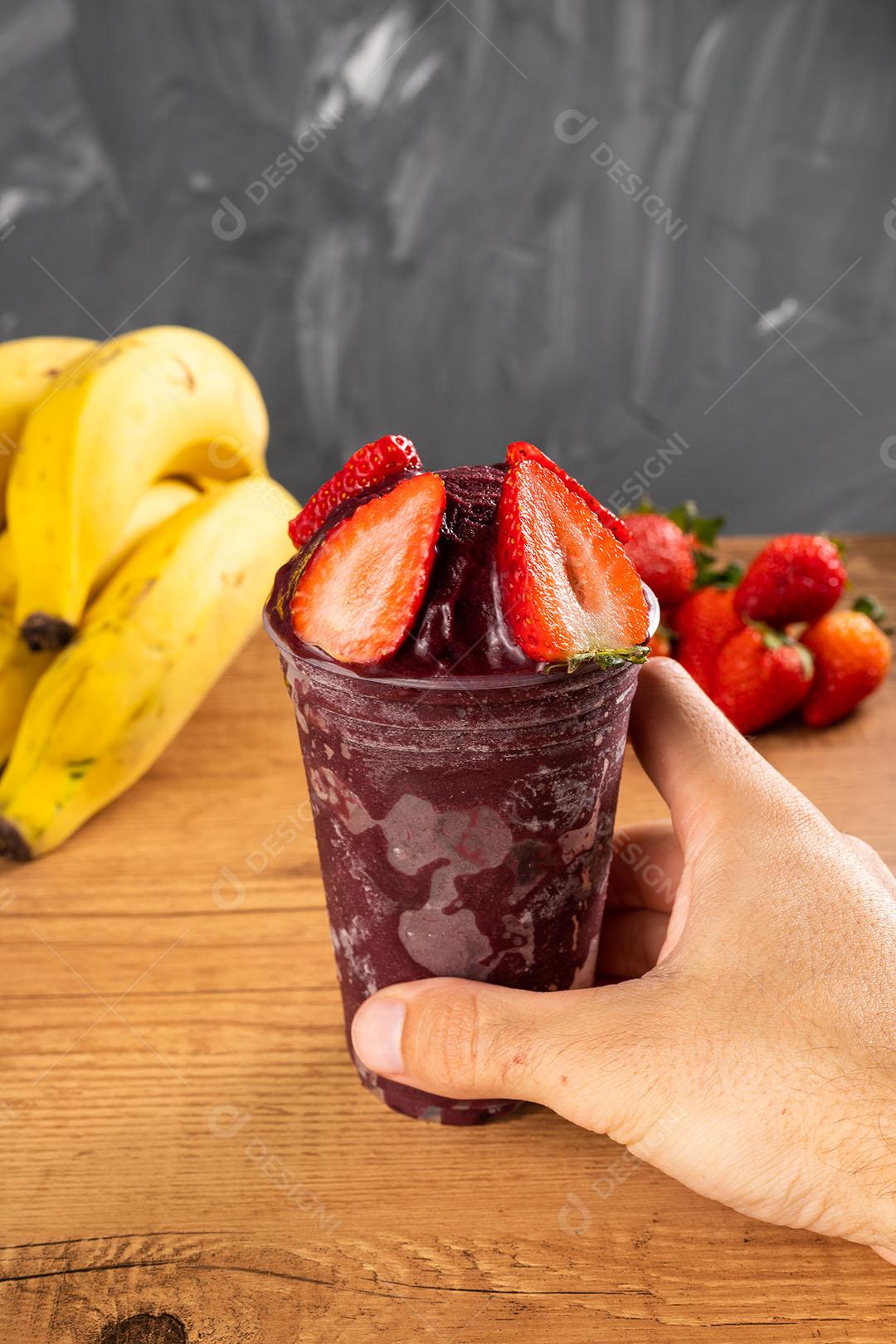 Homem segurando um Smoothie de Sorvete Brasileiro de Açaí Berry Congelado Imagem JPG