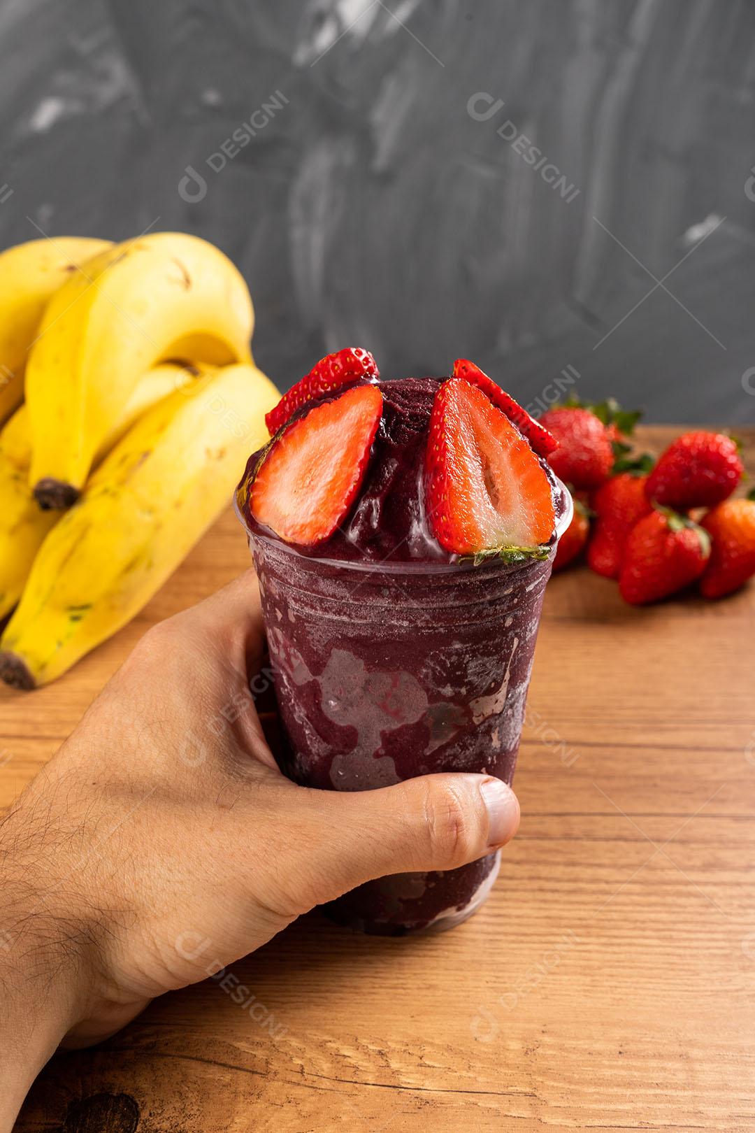 Homem segurando um Smoothie de Sorvete Brasileiro de Açaí Berry Congelado Imagem JPG