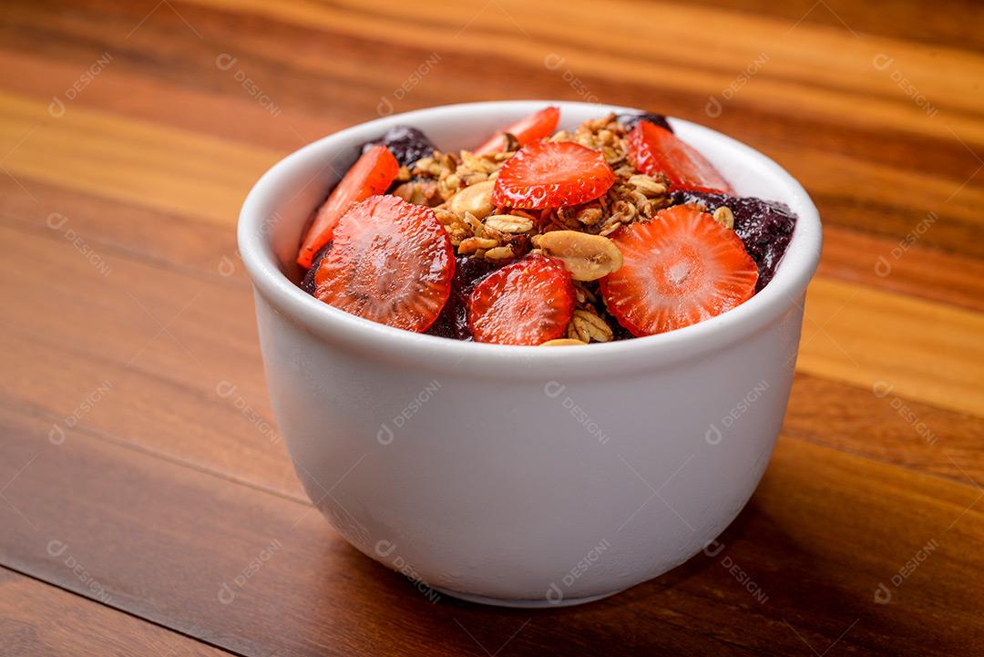 Açaí Brasileiro Com Morango E Granola Em Tigela Branca Sobre Mesa De Madeira Imagem JPG