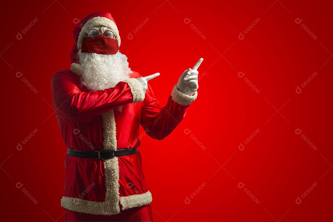 Papai Noel Com Máscara e Apontando o Dedo, Isolado Em Fundo Vermelho Imagem JPG