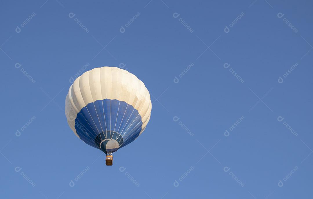 Balão de ar Quente Azul e Branco Voando no Céu Azul Imagem JPG