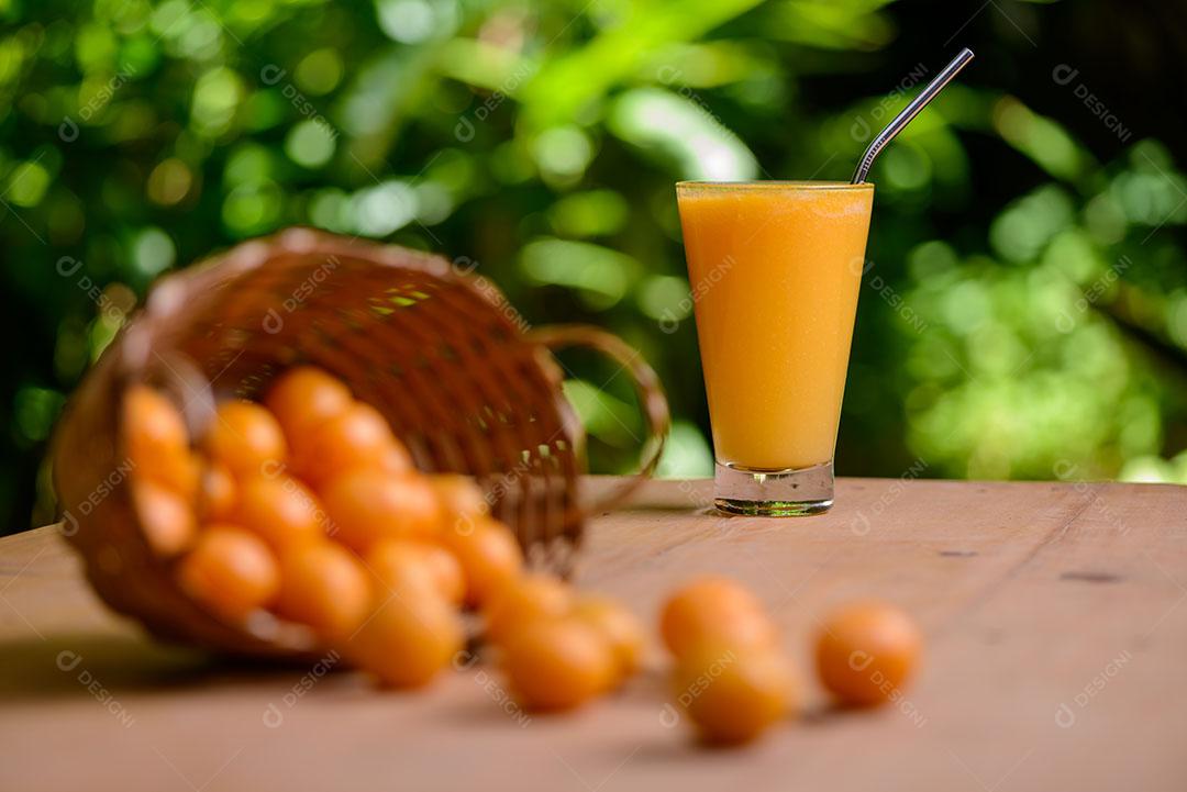 Suco De Caja No Copo Com Canudo Sobre Mesa De Madeira 3 Imagem JPG