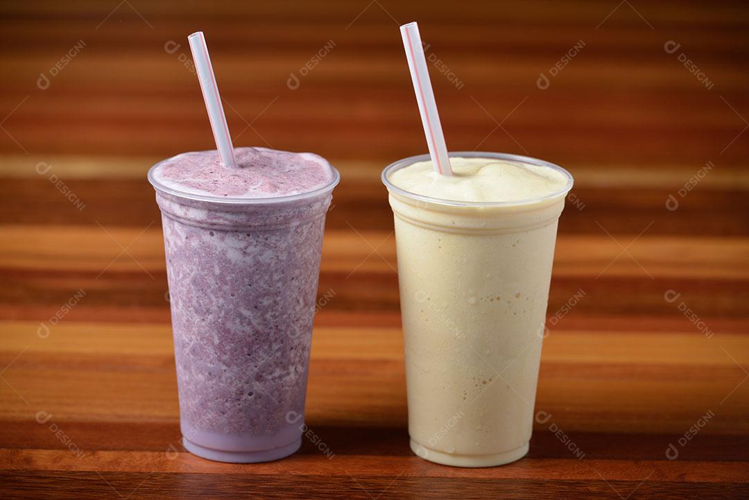 Foto Milk Shake Em Copos Plásticos Canudos Mesa de Madeira Escura Imagem JPG