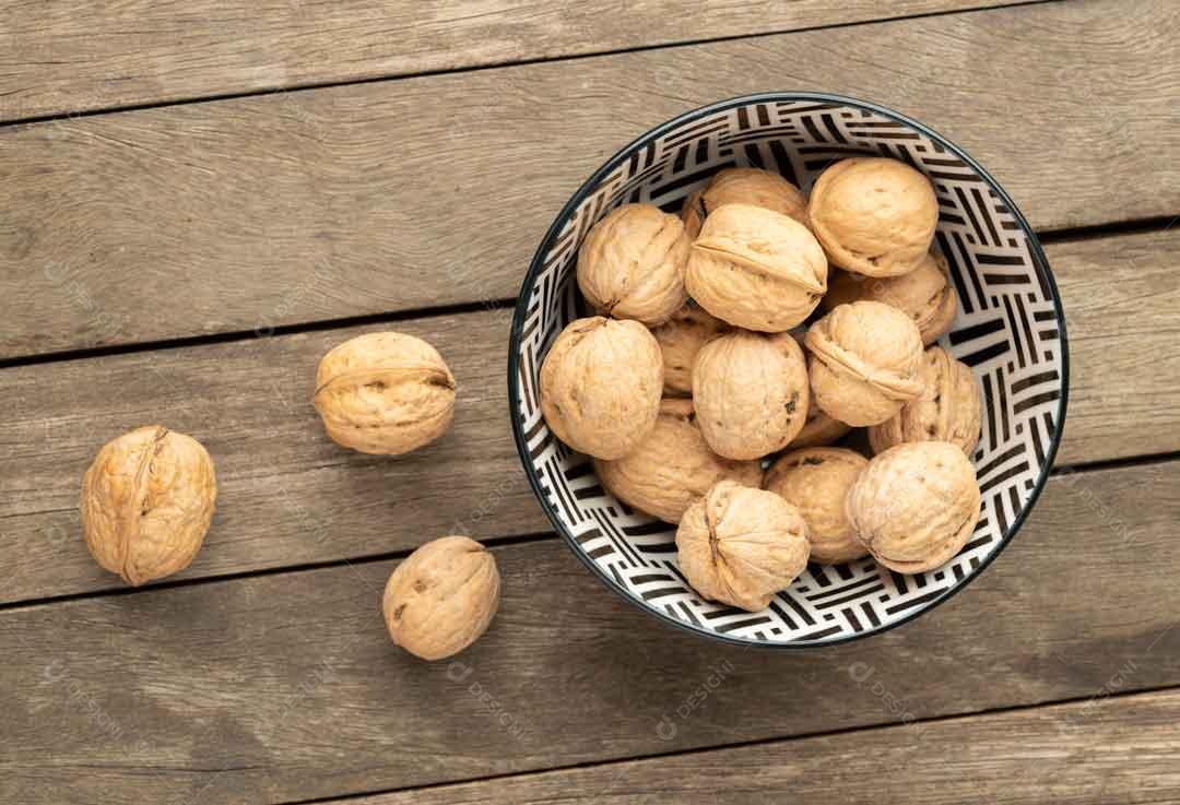 Nozes Espalhadas Pela Mesa E Dentro De Um Pote Imagem JPG