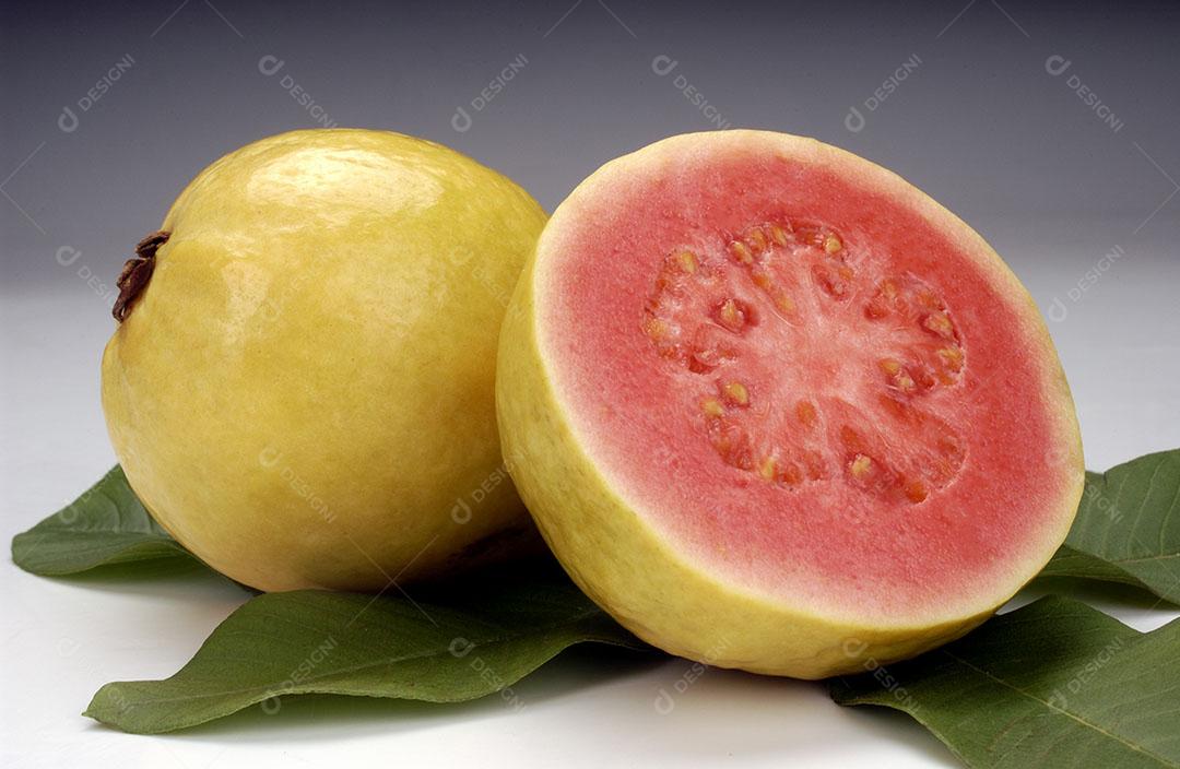 Goiabas Partidas Ao Meio e Folhas Sobre Fundo Branco Fruta Tropical Imagem JPG