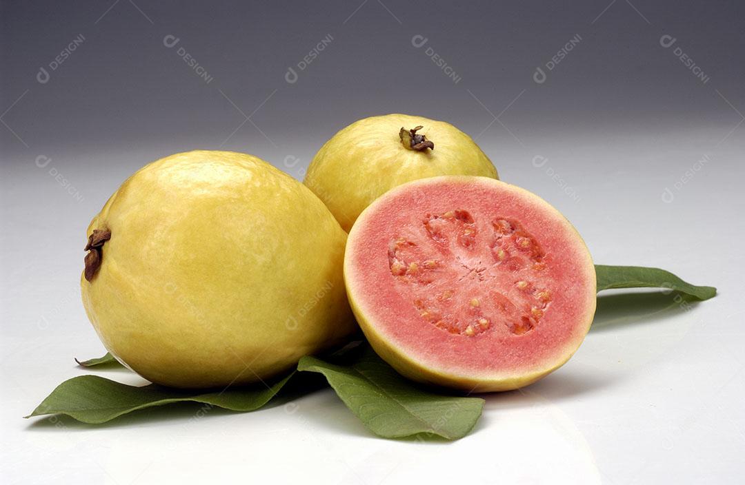 Goiabas Partidas Ao Meio e Folhas Sobre Fundo Branco Fruta Tropical Imagem JPG