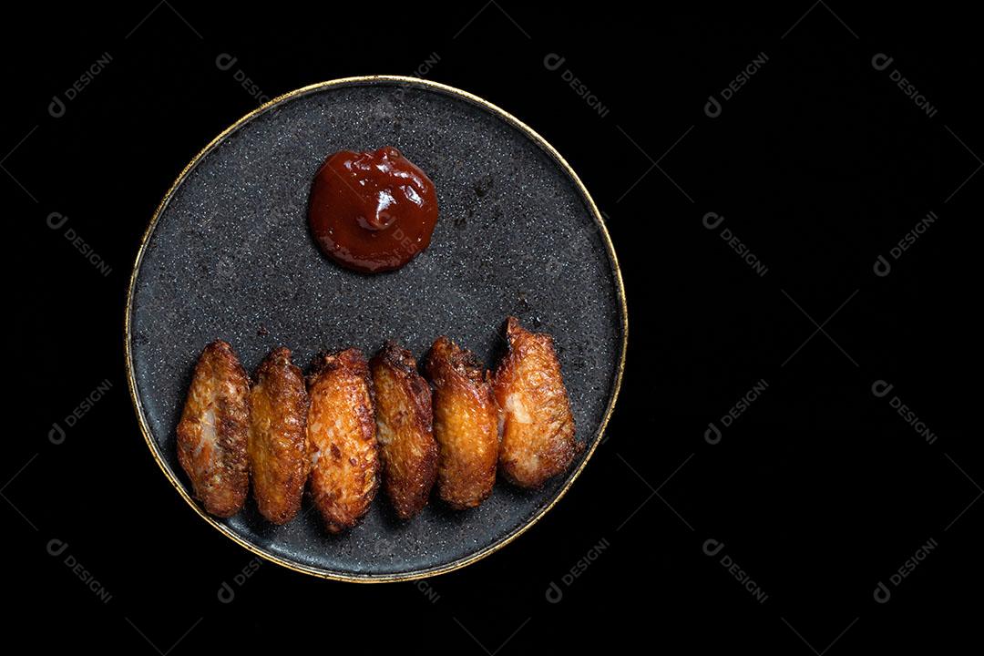 Asas de Frango Frito Em Uma Placa Preta Com Molho de Tomate Imagem JPG