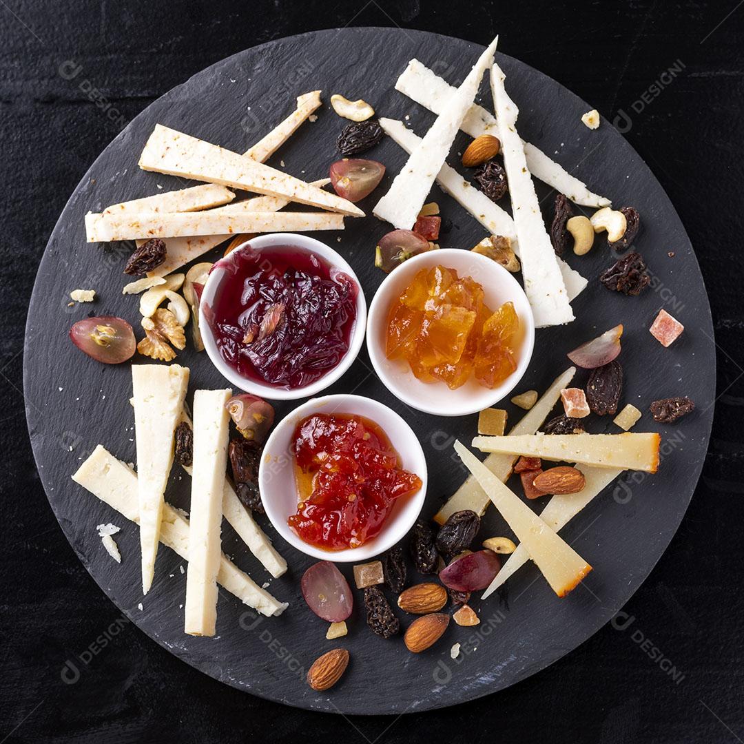 Tábua de Queijos Com Nozes e Marmeladas Em Um Fundo de Mesa Preta Imagem JPG