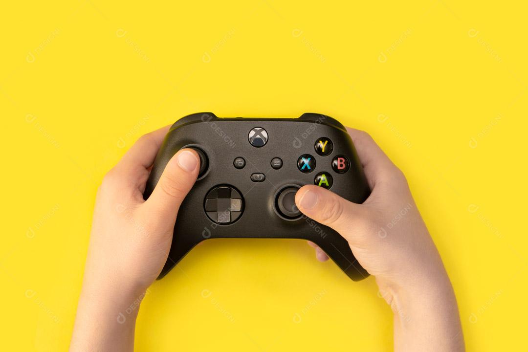 Controlador de Console de Jogos Preto Em Um Fundo Amarelo Imagem JPG