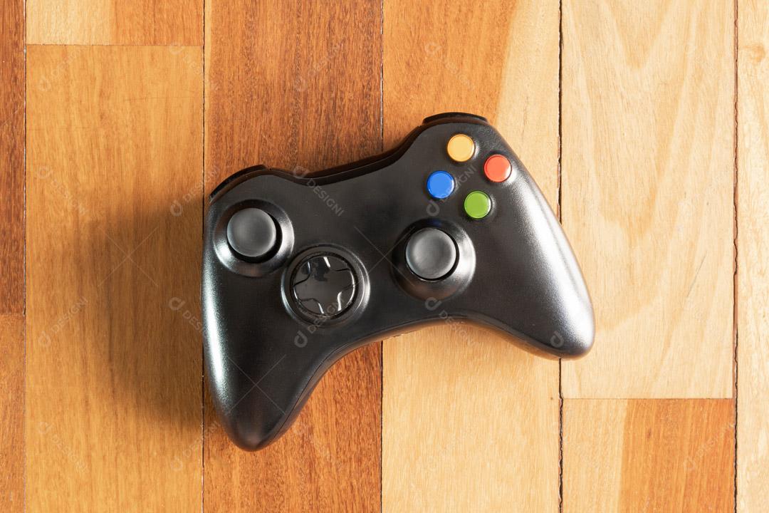 Controlador de Console de Jogos Preto Em Um Fundo de Madeira Imagem JPG