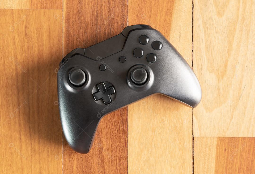 Controlador de Console de Jogos Preto Em Um Fundo de Madeira Imagem JPG