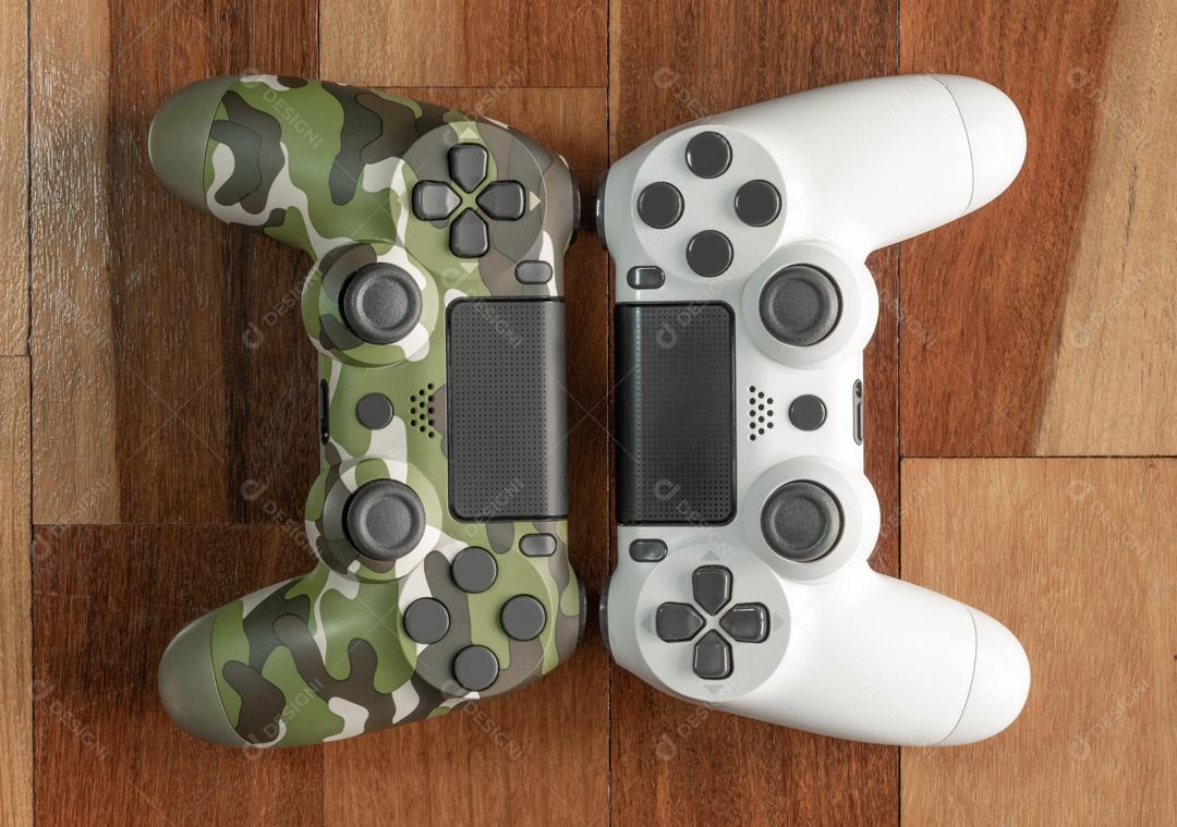 Controladores de Consoles de Jogos Branco e Exército  Em Um Fundo Madeira Imagem JPG