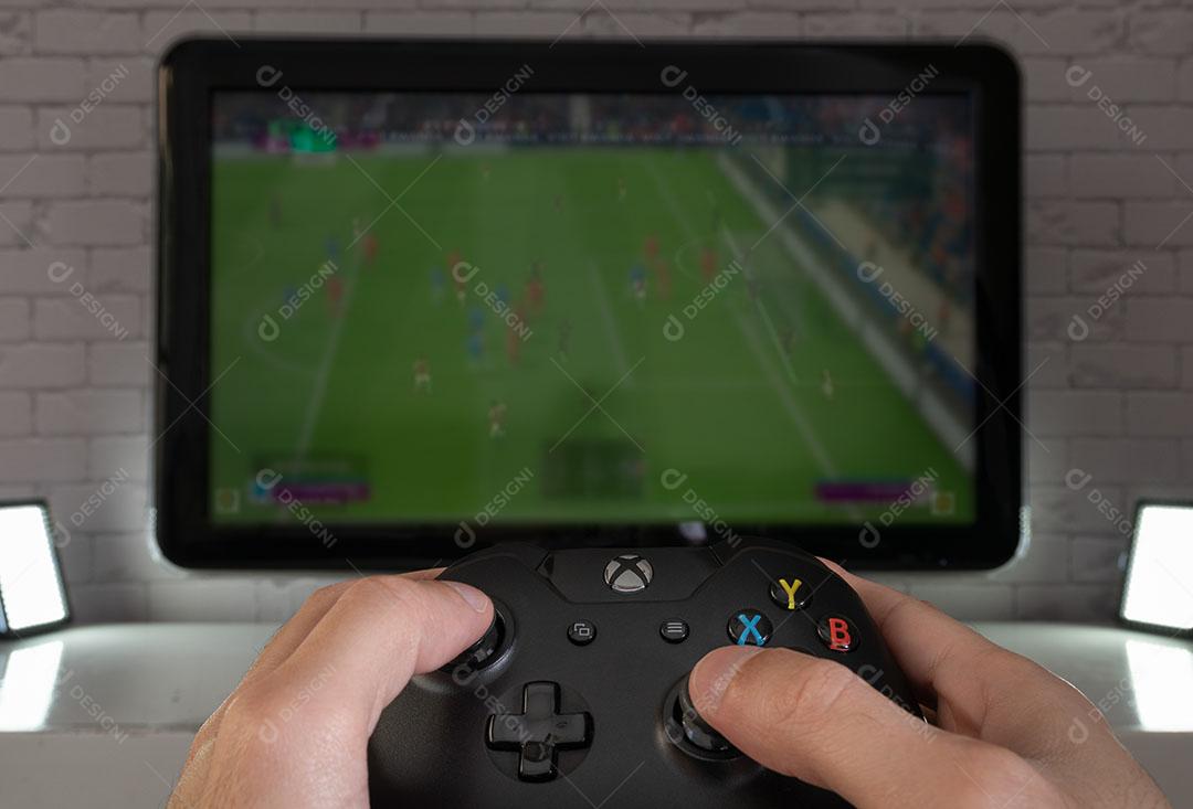 Controlador de Console de Jogos Preto Em Um Fundo De Futebol Imagem JPG