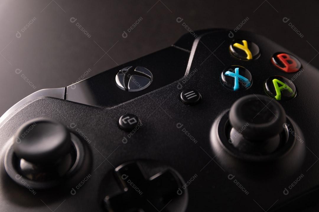 Controlador de Console de Jogos Preto Em Um Fundo Preto Luminado Imagem JPG