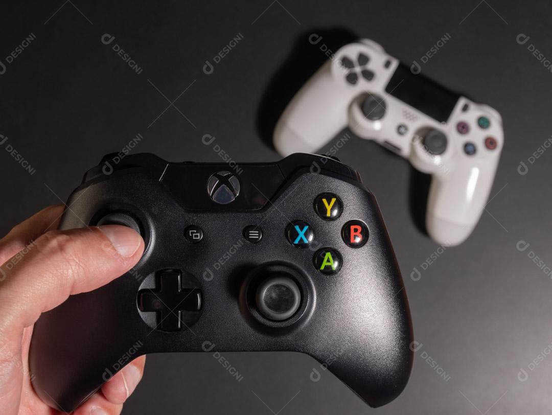 Black and White Game Console Controller in Hand On A Black Background Image JPG