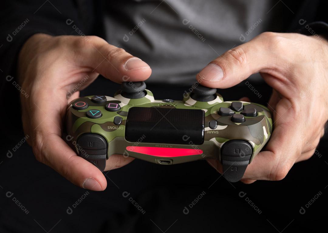 Controlador de Console de Jogos do Exército na Mão Em Um Fundo Preto Imagem JPG