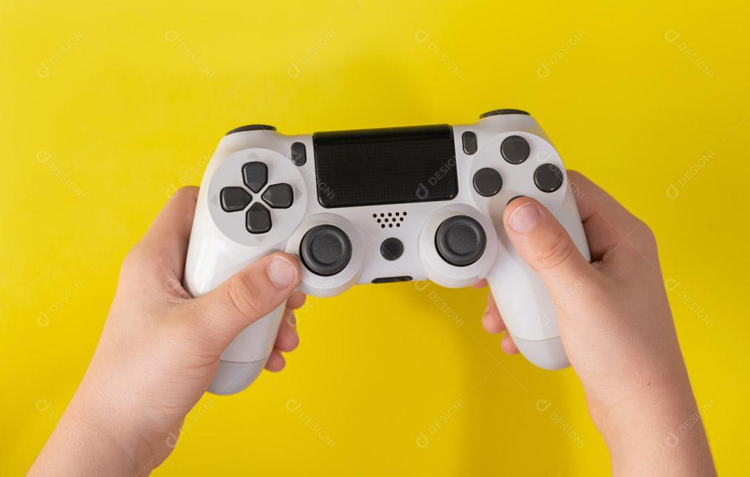 Controlador de Console de Jogos Branco na Mão Em Um Fundo Amarelo Imagem JPG