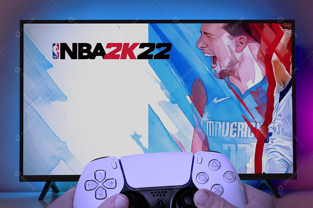 Menino jogando NBA 2K22 na TV com controle do Playstation 5 Imagem JPG