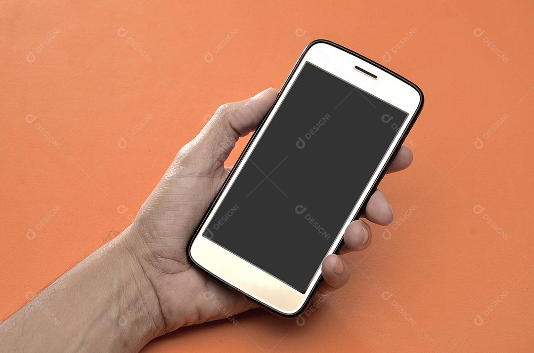 Mão Masculina Segurando Celular Em Fundo Laranja Imagem JPG