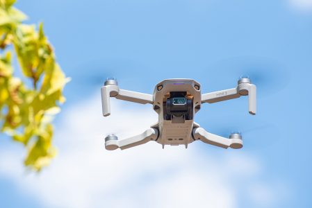 Drone Dji Mini 2 e Controle Sobre Superfície de Madeira e Fundo Abstrato Imagem JPG