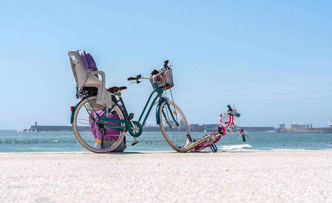 Foto Bicicleta de Mãe e Filha Parada na Praia Em Um Agradável Dia de Passeio Em Família