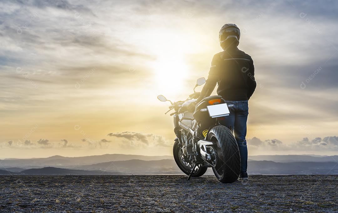 Motociclista Ao Lado da Motocicleta Assistindo o Pôr do Sol Imagem JPG