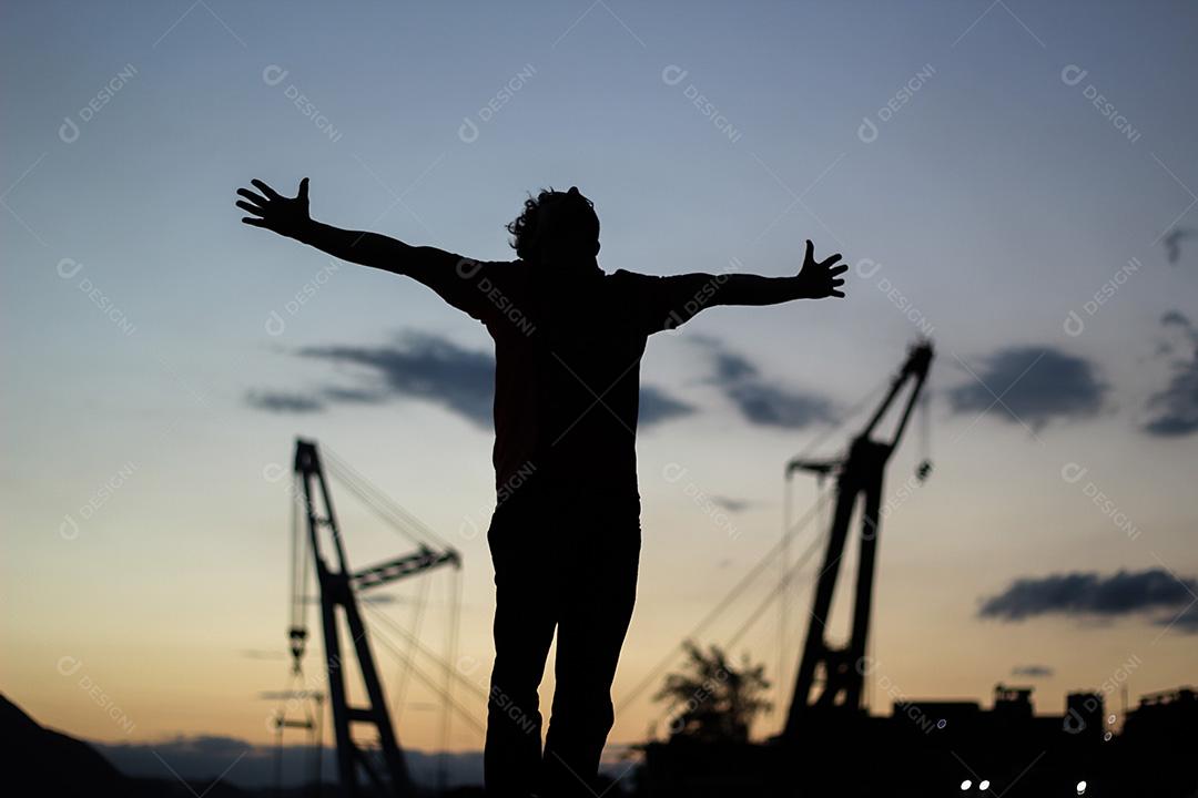 Jovem Rapaz de Braços Aberto Olhando Para Paisagem Imagem JPG