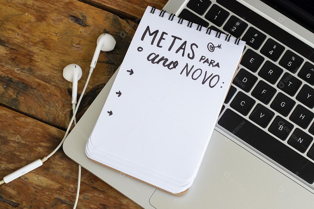 Metas para o Ano Novo Bloco de Notas Sobre um Laptop na Mesa de Madeira JPG