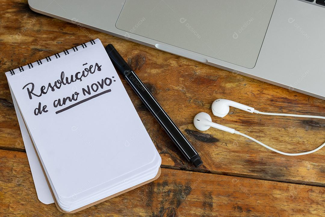 Resoluções de Ano Novo Bloco de Notas Sobre um Laptop na Mesa de Madeira JPG