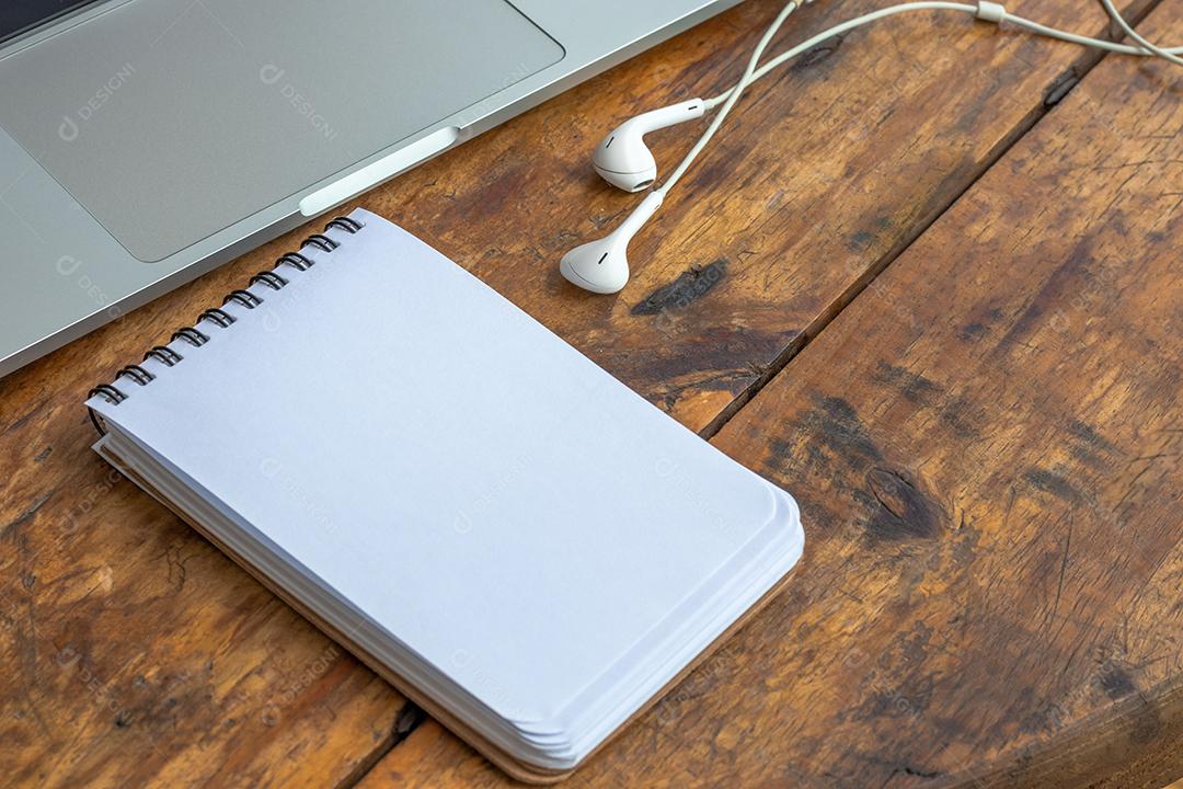 Bloco de Notas em Branco Sobre um Laptop na Mesa de Madeira JPG