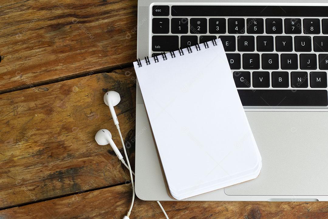 Bloco de Notas em Branco Sobre um Laptop na Mesa de Madeira JPG
