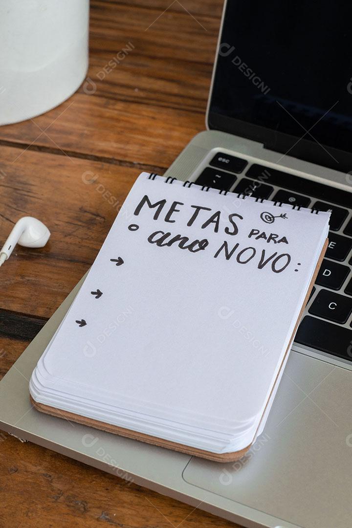 Metas para o Ano Novo Bloco de Notas Sobre um Laptop na Mesa de Madeira JPG