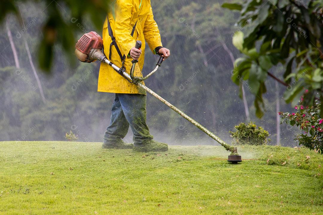 Trabalhador Cortando Grama no Quintal verde JPG