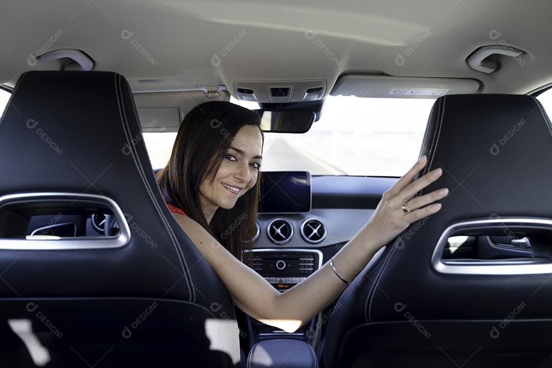 Foto Mulher Sentada Ao Volante de Um Carro Olha para Trás Sorrindo