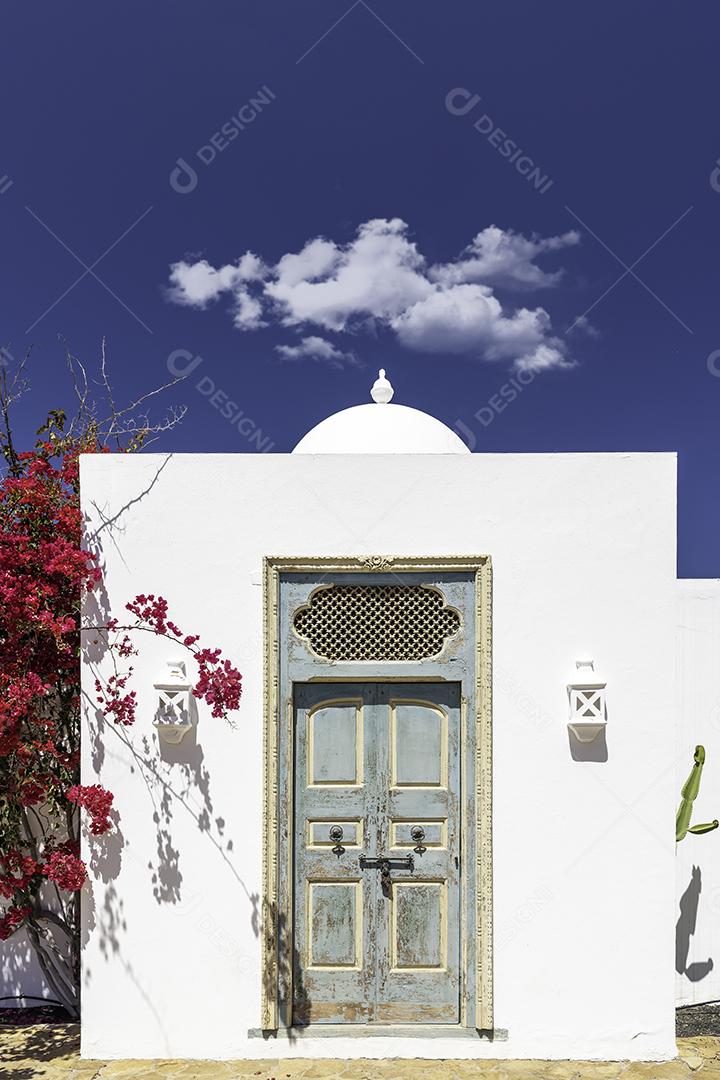 Foto Entrada para Casa Rústica Elementos Árabes e Flores Vermelhas na Parede Lateral
