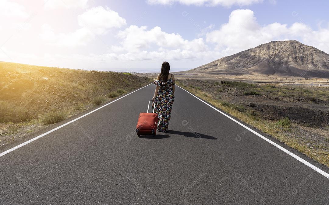 Mulher Com Mala Vermelha Em Uma Estrada Deserta na Paisagem Árida Imagem JPG