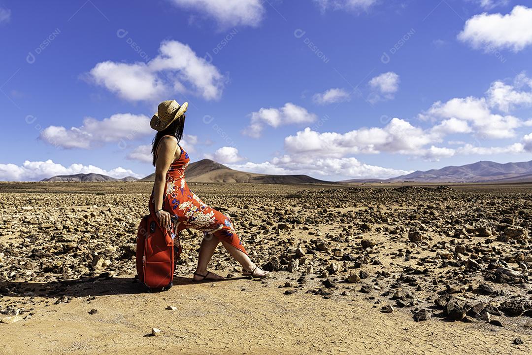 Mulher Com Mala Vermelha Em Uma Estrada Deserta na Paisagem Árida Imagem JPG