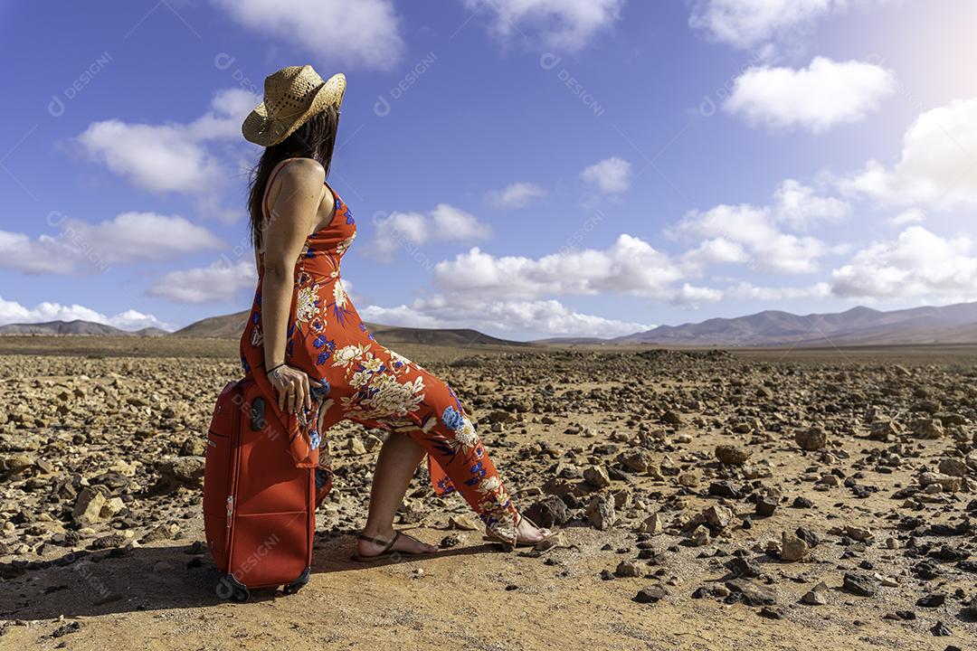 Mulher Com Mala Vermelha Em Uma Estrada Deserta na Paisagem Árida Imagem JPG