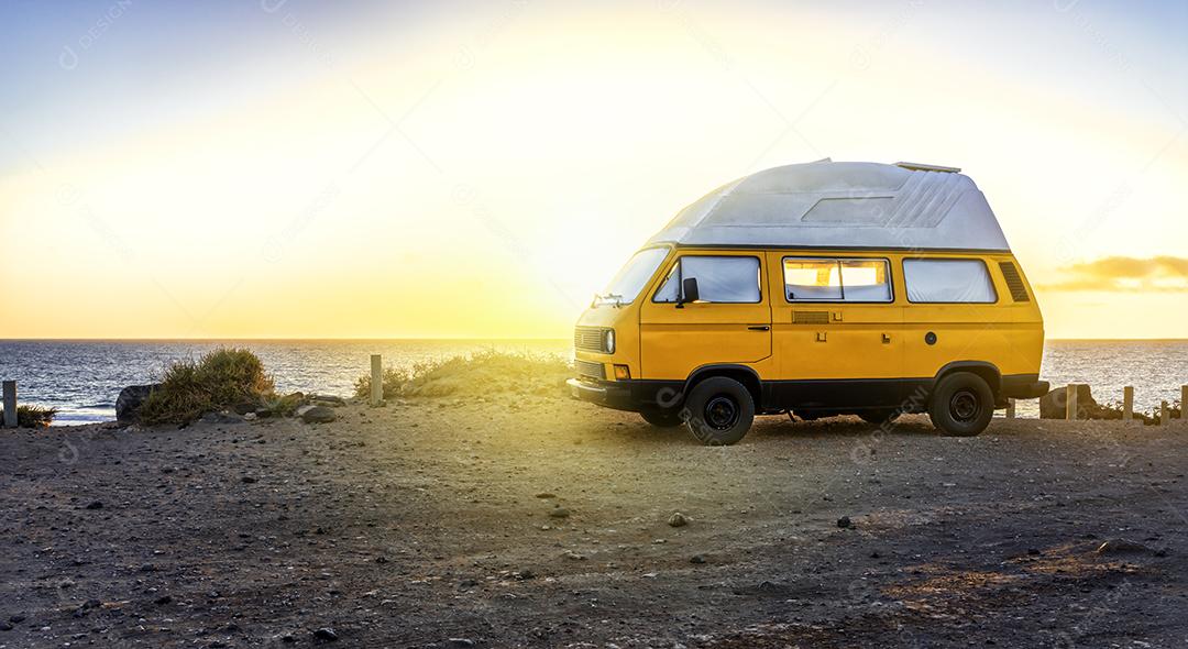 Van de Acampamento Amarela Em Pé no Penhasco Ao Pôr do Sol Imagem JPG