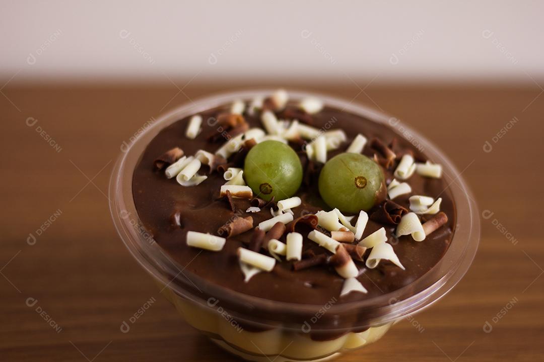 Pote com mousse de chocolate branco e preto com uva e flocos de chocolate