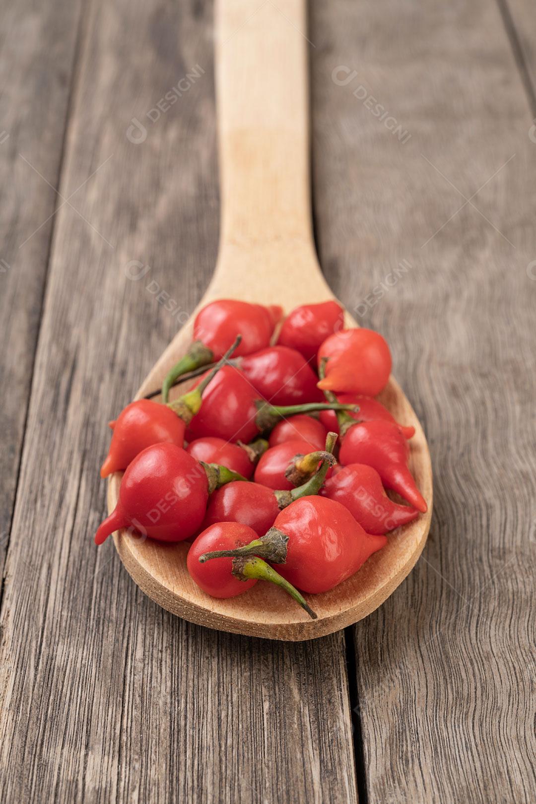 Pimentas em Colher de Madeira Sobre uma Mesa Imagem JPG