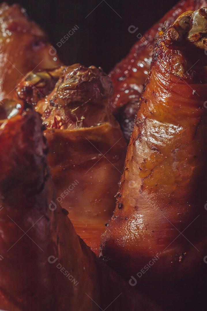 Fotos joelho de porco em uma placa de madeira e soprador de calor arrancando a pele