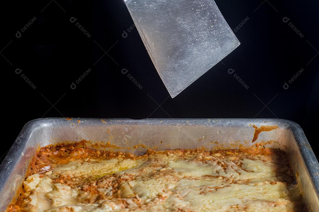 lasanha sendo montada à mão colocando queijo Imagem JPG