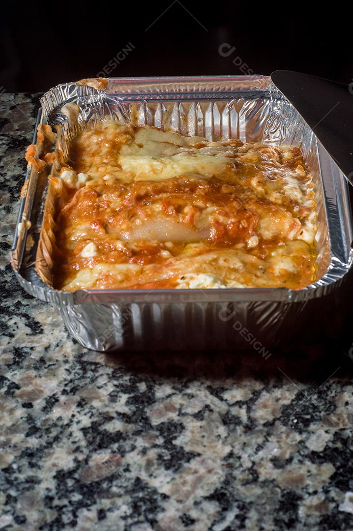 lasanha sendo montada à mão colocando queijo Imagem JPG