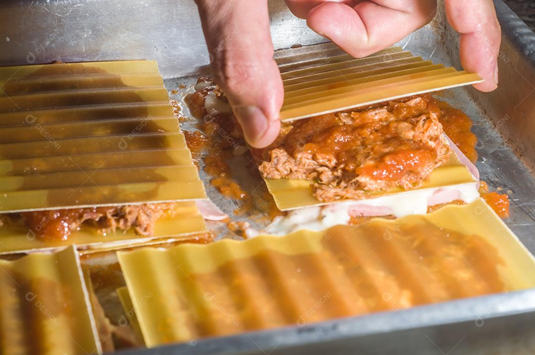 Fotos lasanha sendo preparada com carne de porco desfiada, carne de porco desfiada