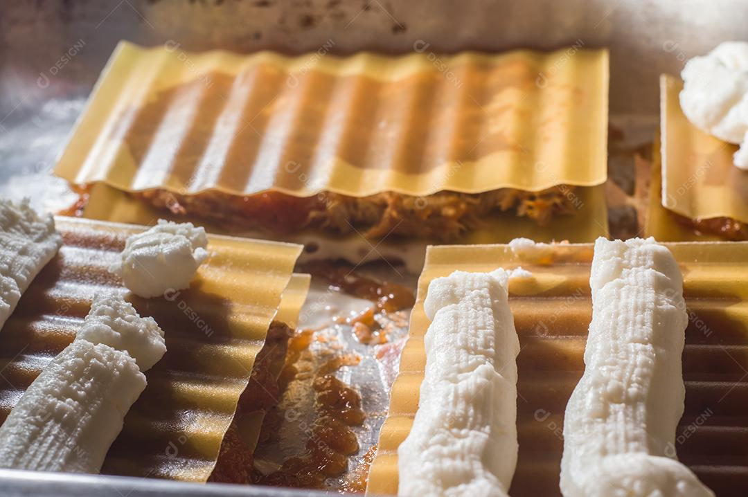 Fotos lasanha sendo preparada com carne de porco desfiada, carne de porco desfiada