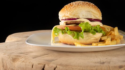 Hambúrguer E Batatas Fritas Colocadas Em Um Prato Branco Sobre Mesa Imagem JPG